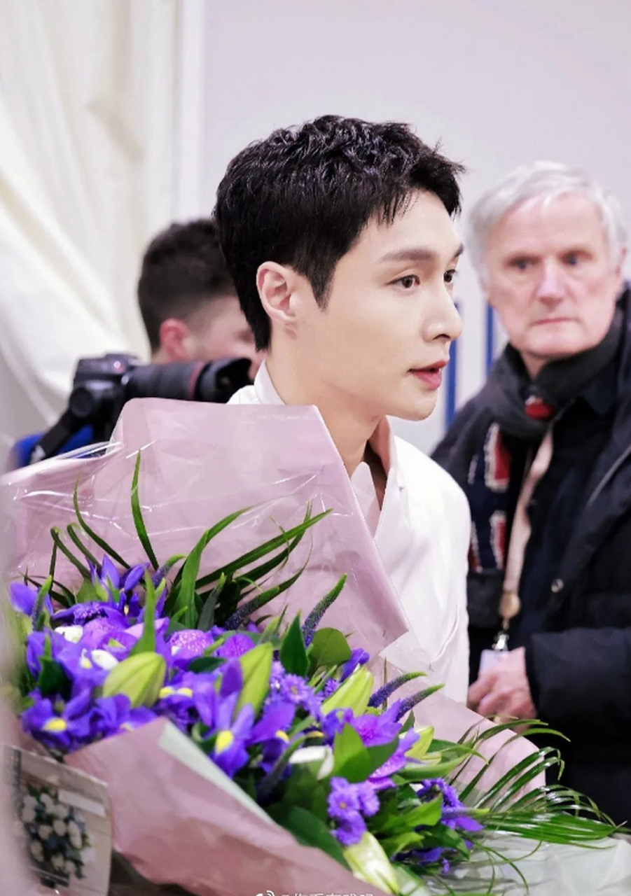 张艺兴在国外活动路透,身穿粉西装,利落短发,看起来清爽帅气,手上拿着