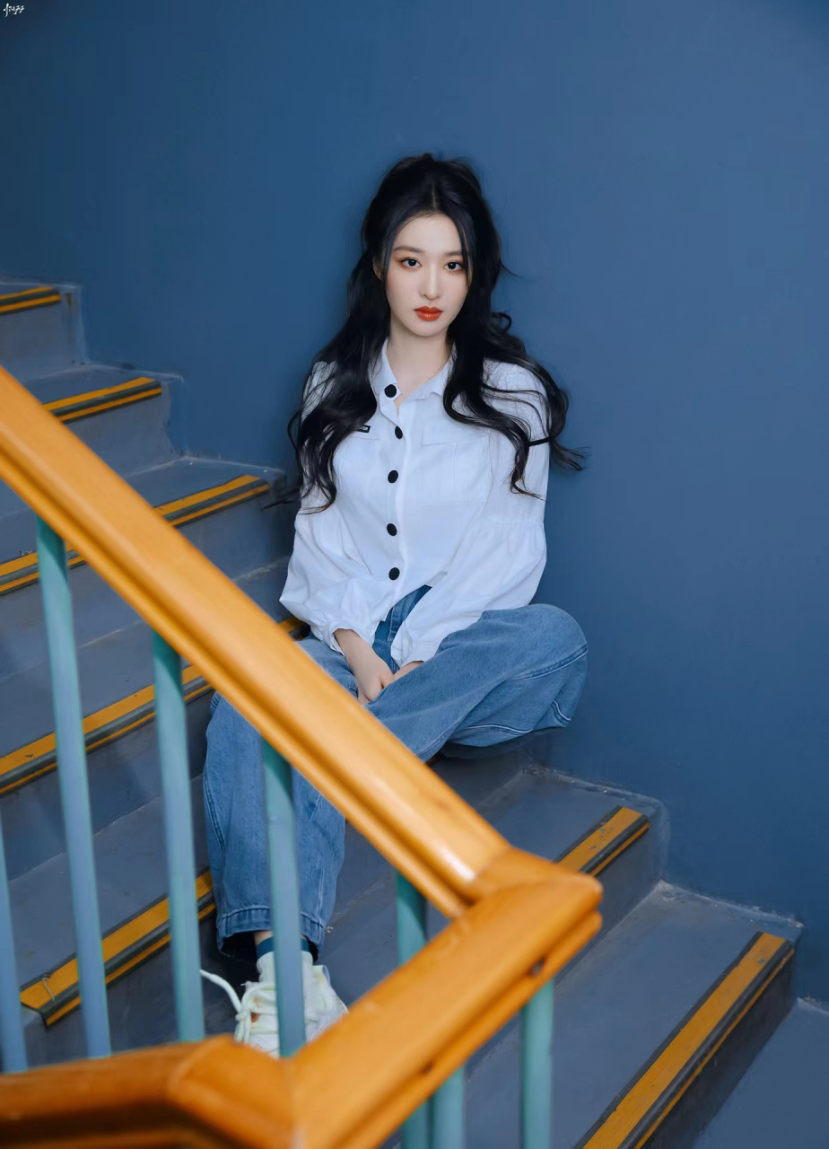 照片中的王楚然,穿着白色灯笼袖衬衫,下身搭配牛仔裤,扎着青春活力的