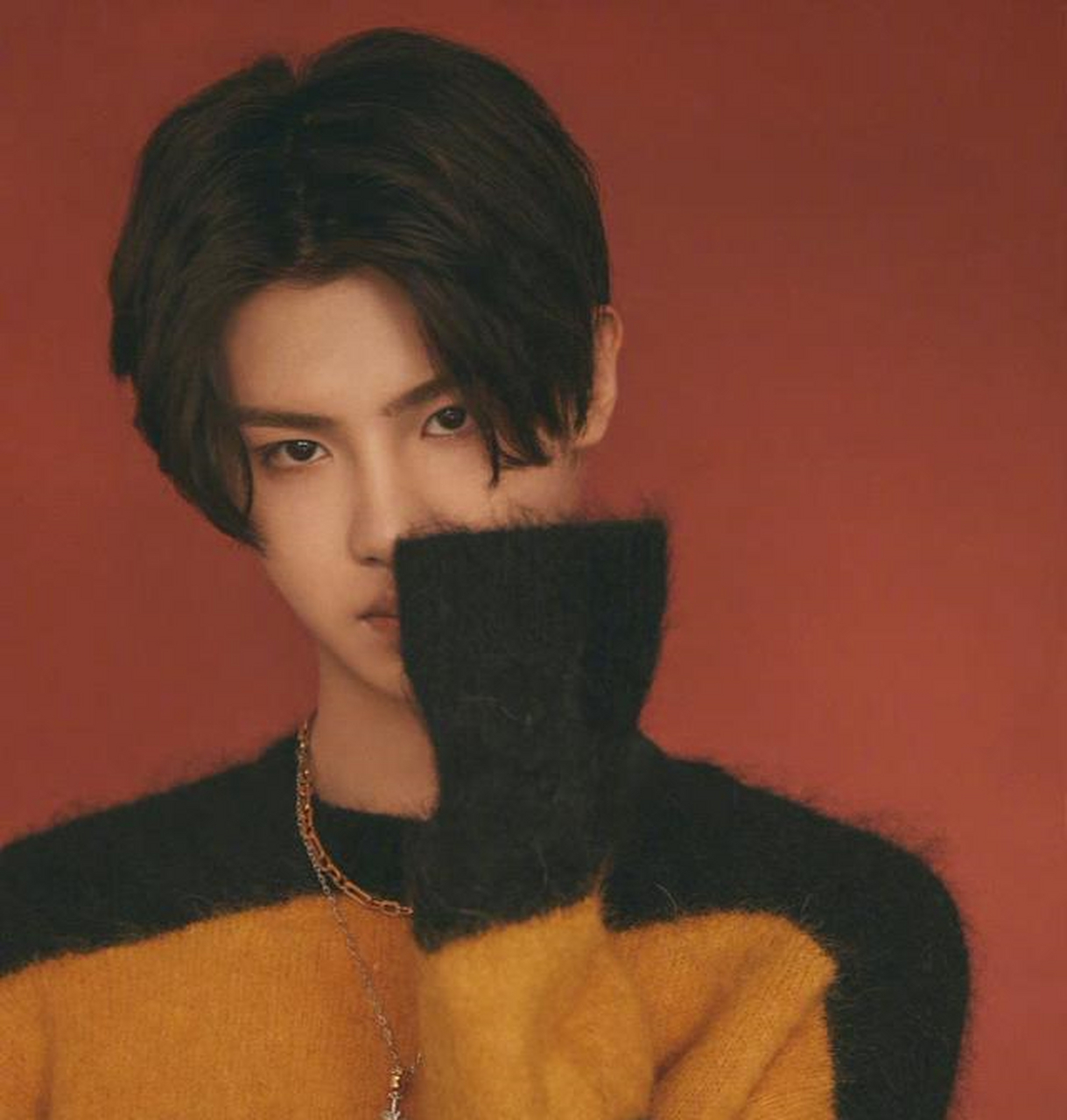 黄明昊身穿橙黑条纹针织衫,中分黑发尽显温柔潮男气质