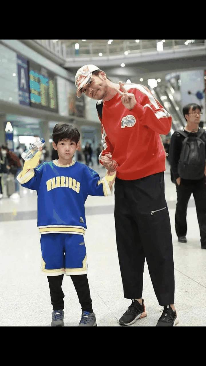 杨烁一身休闲街头范儿,穿橘红色卫衣 黑色休闲长裤,看起来宽松舒适