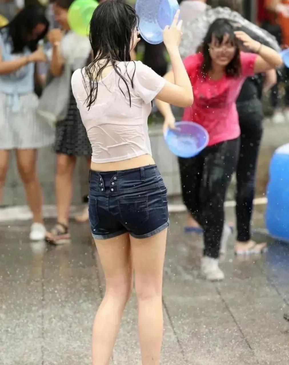 图片中的美女从街头路过,无一不被泼到全身湿透,印出玲珑剔透的身材!