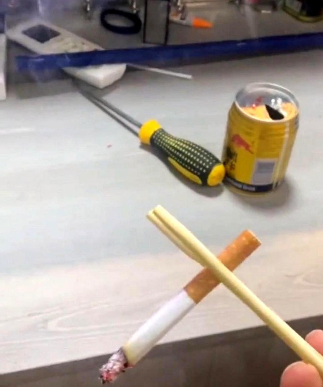 这个人真有讲究,甚至用筷子夹着烟.