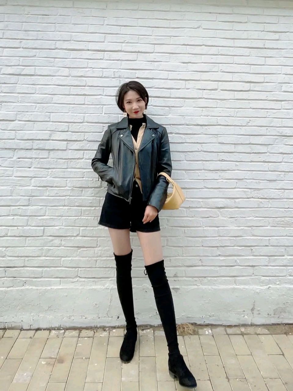 30岁女生的春秋穿搭: 穿上黑色皮衣,搭配黑色长筒靴和黑色短裤,霸气