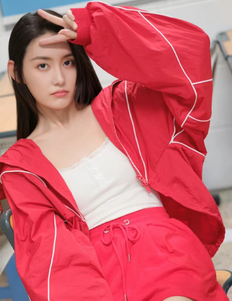 蒋依依一身红色运动装出镜拍摄,表情俏皮显活泼,黑长直的发型一看就是