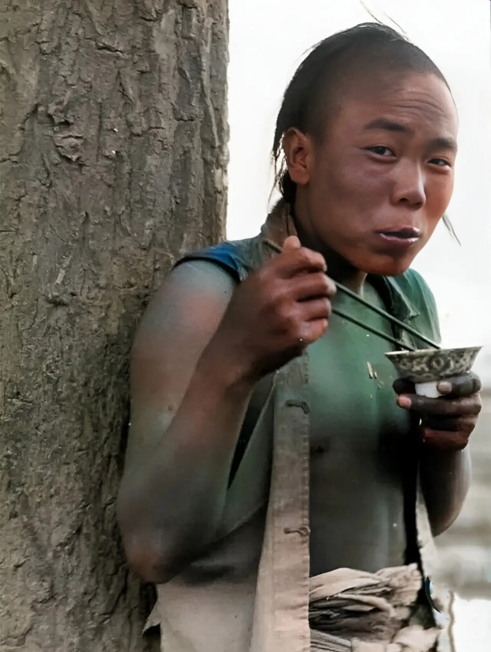 1909年,一位蓬头垢面,衣衫褴褛的男子正在有滋有味地吃饭.