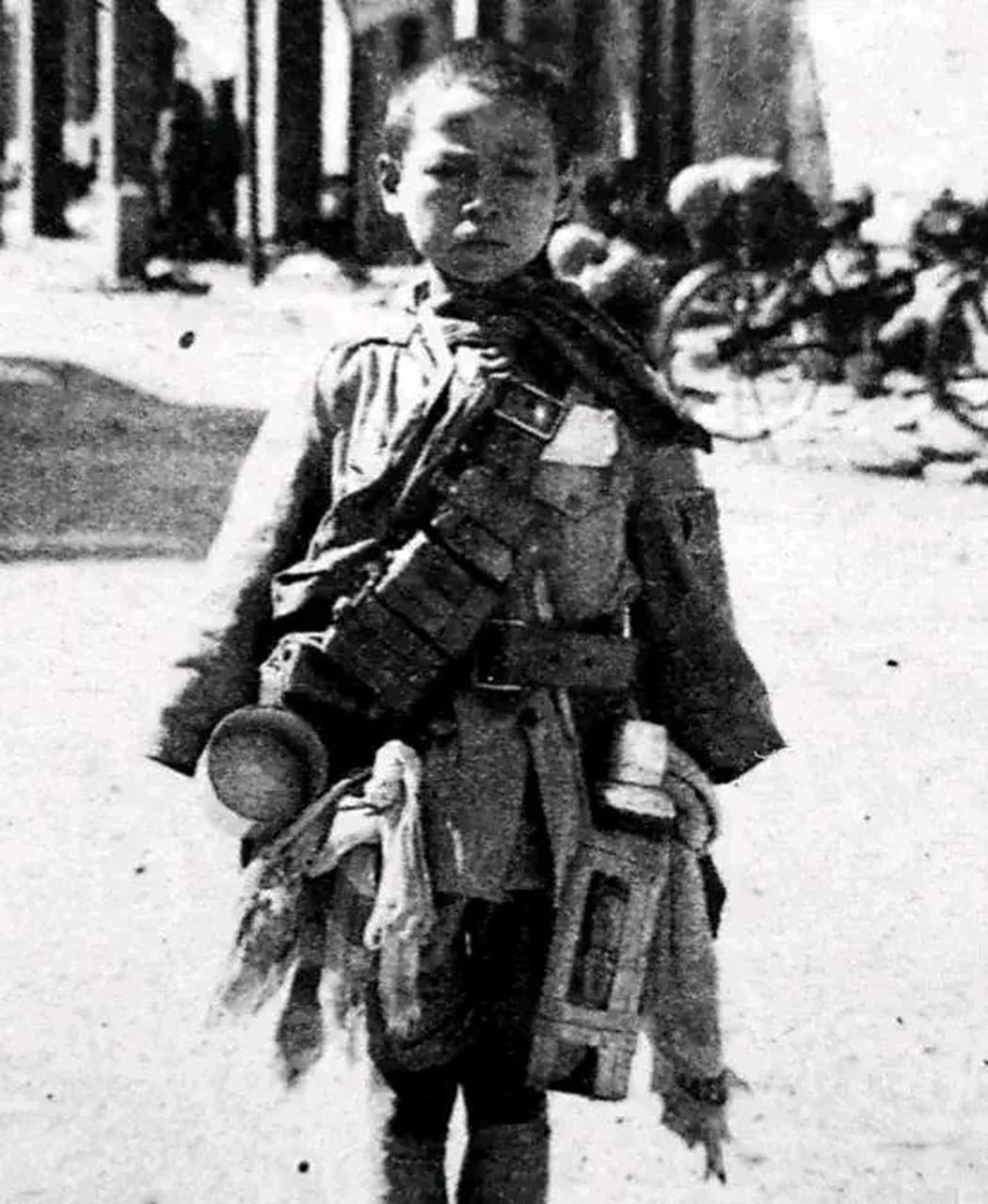 1938年10月,日本随军记者给15岁的俘虏小战士季万方拍照炫耀"战果".