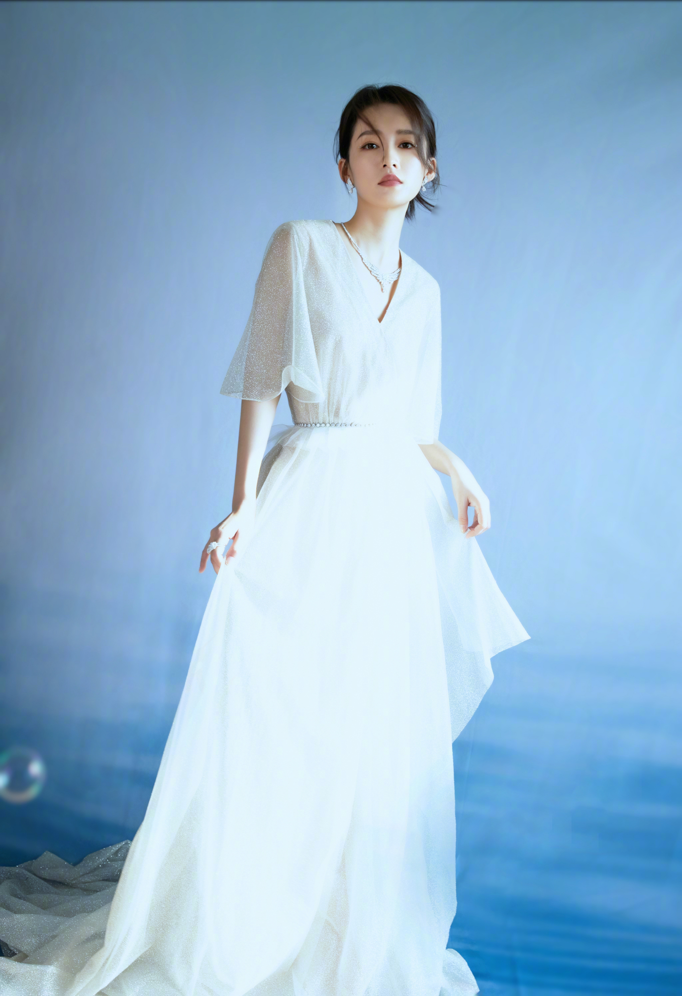 李沁身穿银白色轻纱礼裙仙气优雅,泡泡置景增添梦幻质感