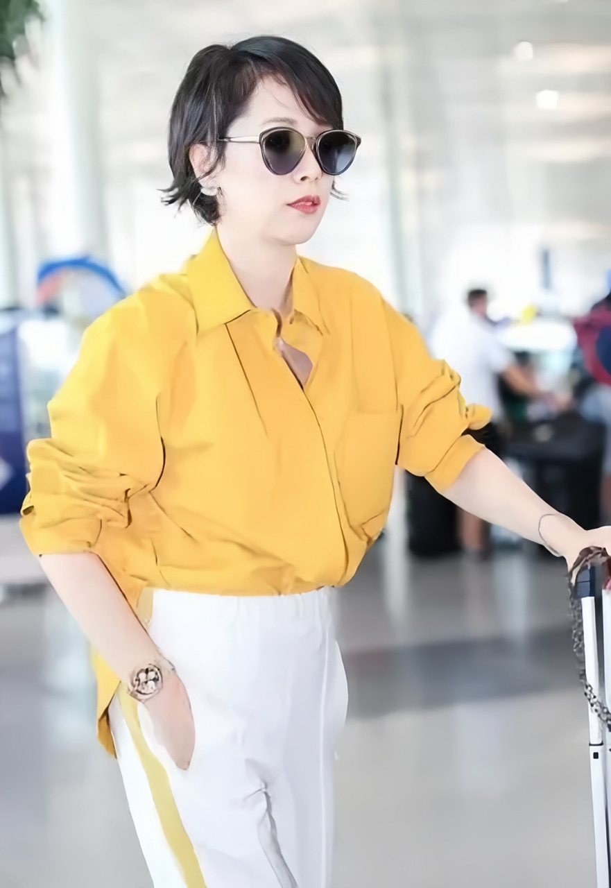 美感,她出行时选择了一套黄色衬衫搭配运动裤,整体造型散发出青春活力