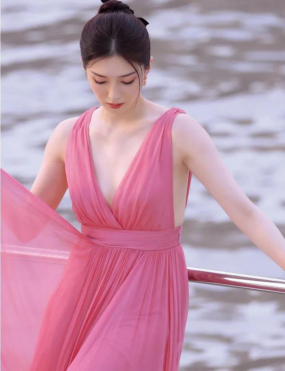 江疏影身穿玫红色长裙站在海边,展现出一种纯净而迷人的气质.
