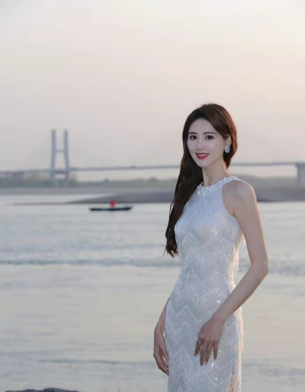 电影频道女主持李丹身穿白色闪片长裙,展现窈窕的曲线和知性美  近日