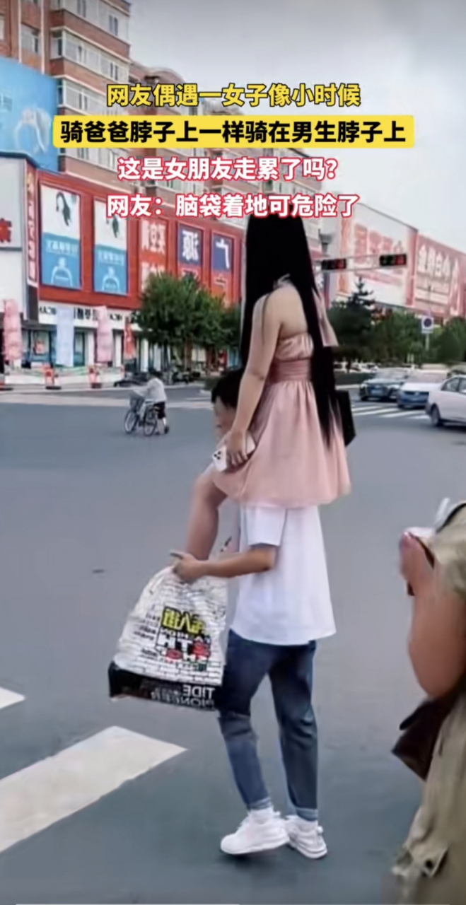 女子骑在男朋友脖子上过马路,被人围观拍照,仍然淡定走过,内心是真的