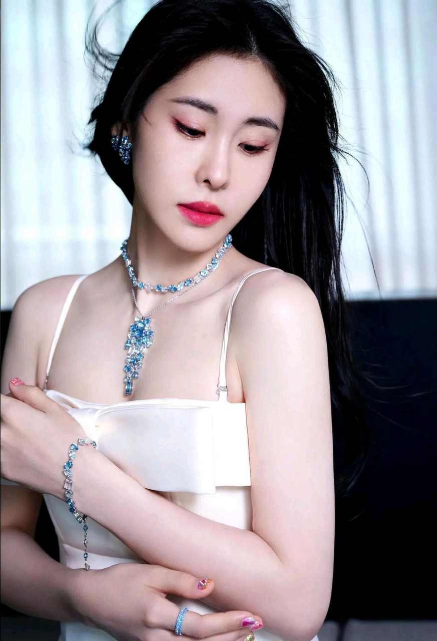 张碧晨,在一个装饰复古的内室中,身穿一袭优雅迷人的白色吊带抹胸礼服