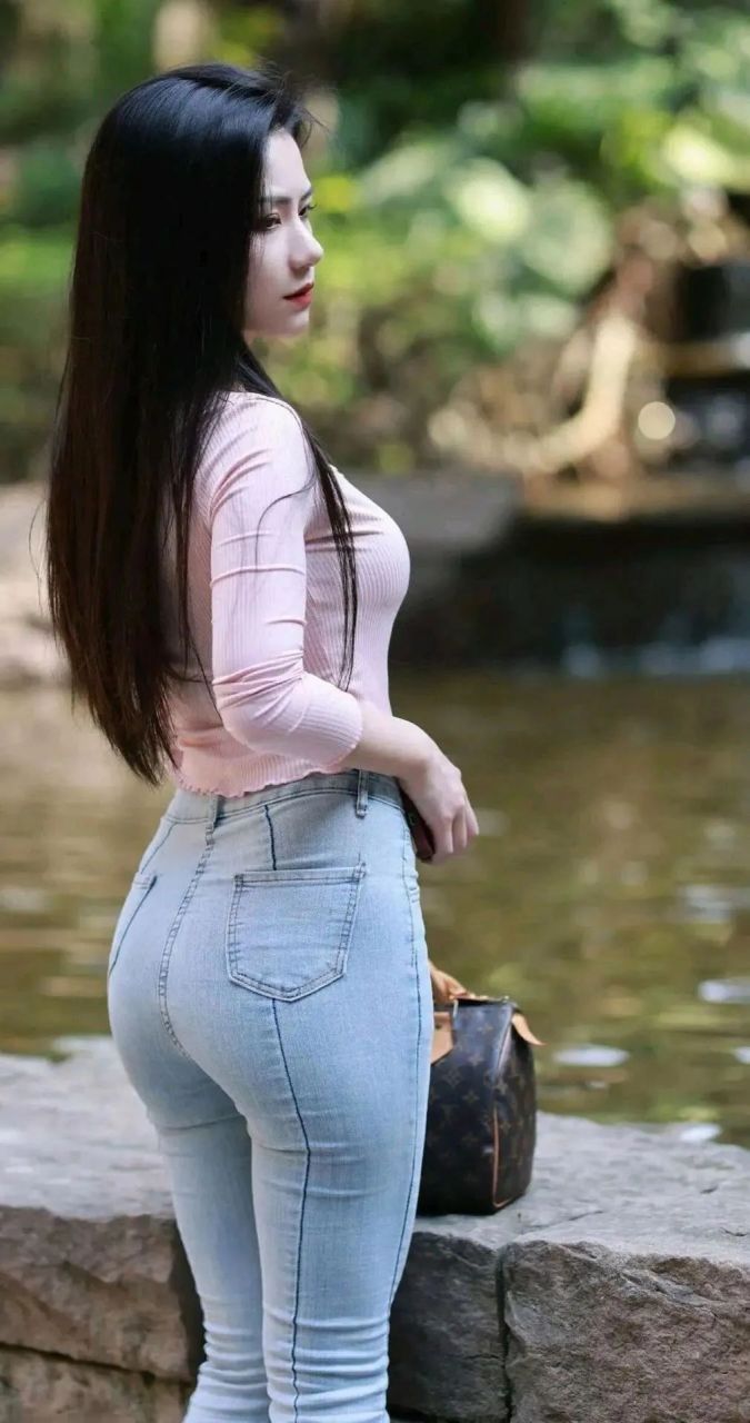 小溪边长发紧身牛仔裤美女
