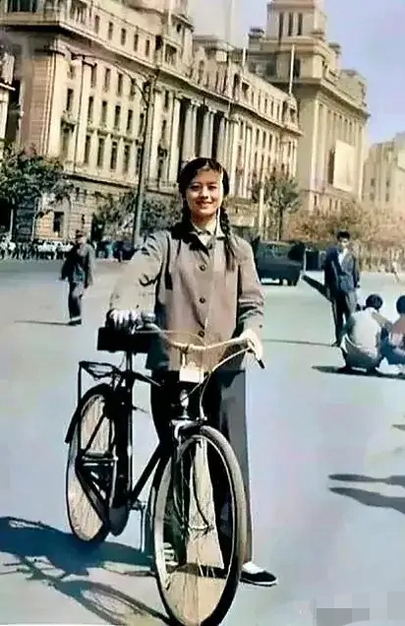 70年代上海街头,一个年轻漂亮的女孩,推着她的自行车留下的一张照片.