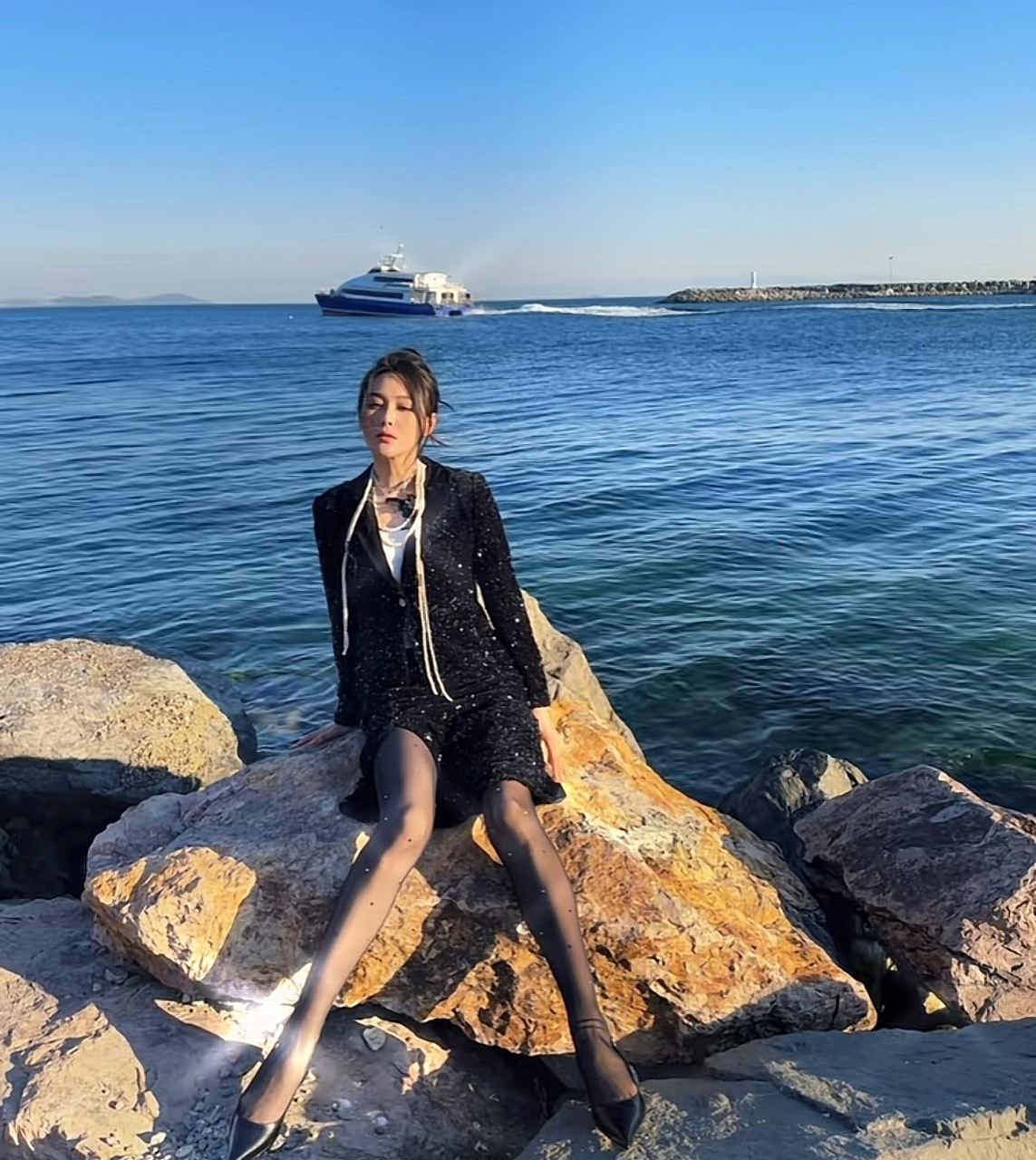 张馨予海边拍大片,她穿着高跟鞋坐在礁石上凹造型,一米七的身高有种