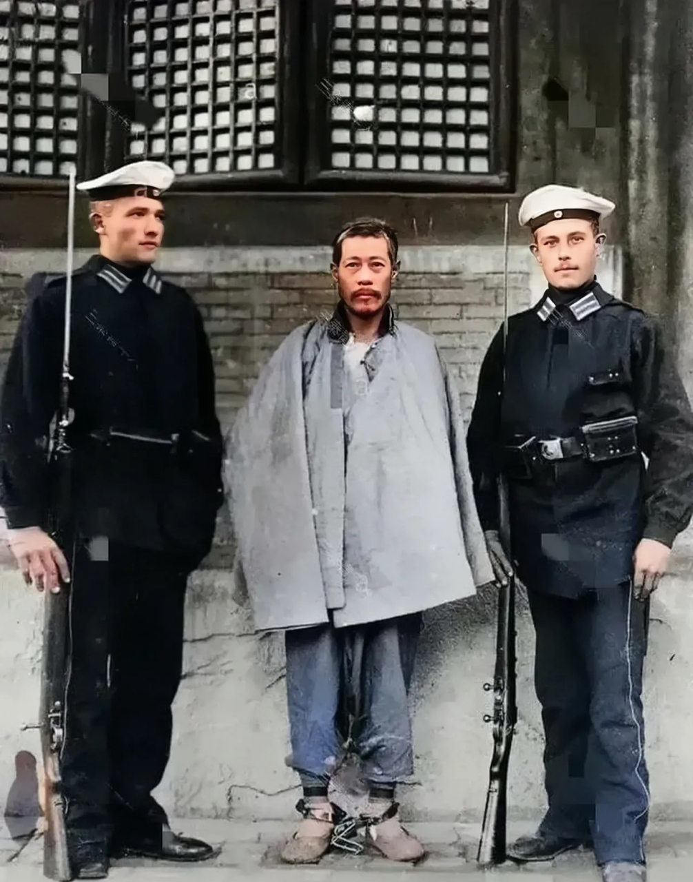 照片中站在两个德国鬼子中间,身体瘦弱,戴着脚镣的男子值得我们所有