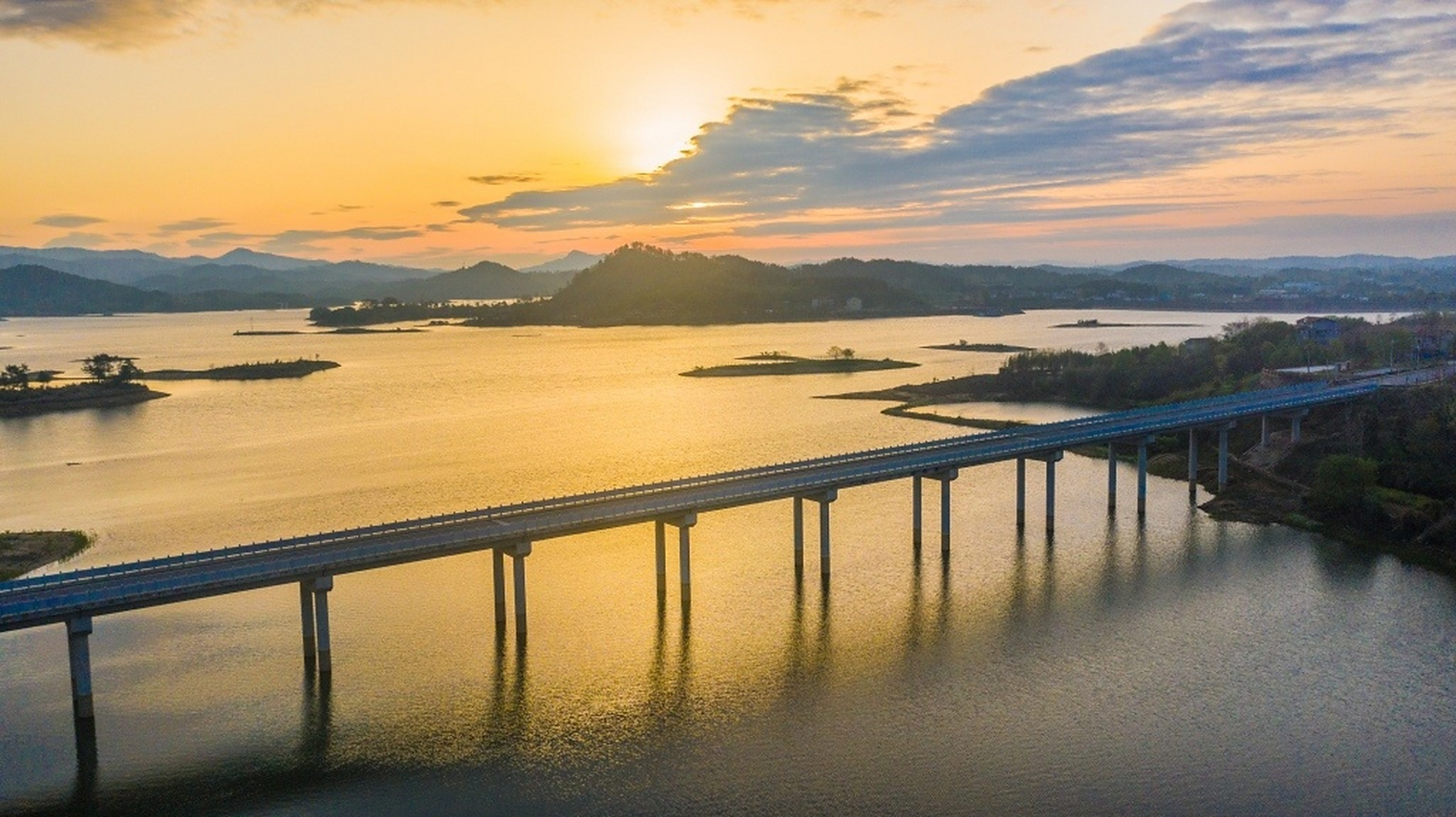 湖北黄冈,牛车河水库上空朝霞灿烂,映在平静的水面