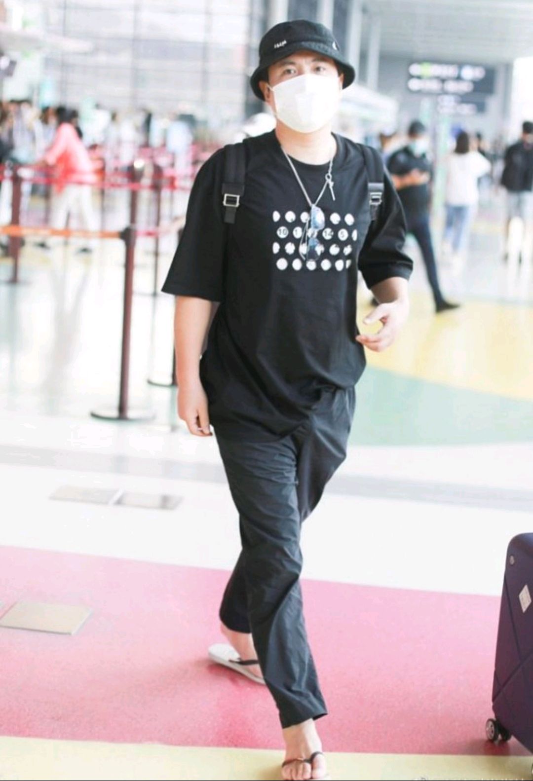 沈腾穿着人字拖走机场,黑色假两件t恤搭配黑色裤子,酷劲十足!