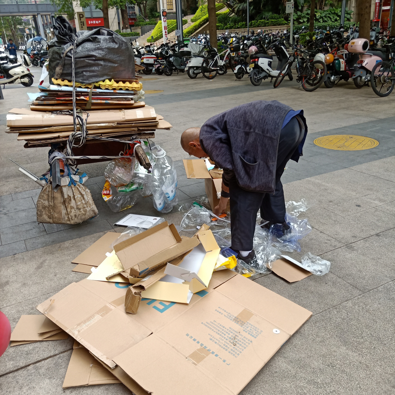 虽说老人捡纸皮废品的不少,但像大爷这把年纪还拉着板车的,这个城市