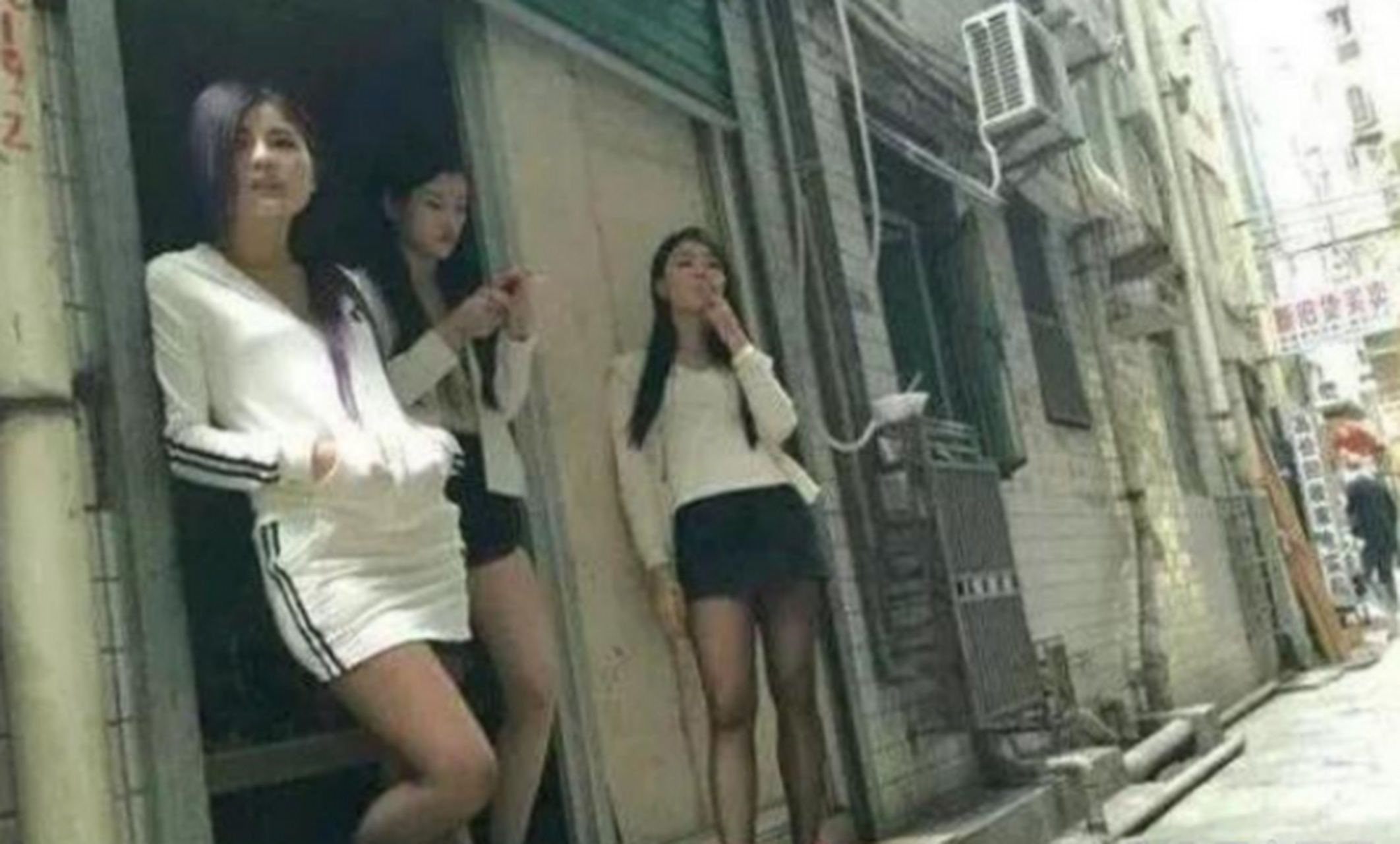 上世纪90年代,深圳街头几名打扮得花枝招展的姑娘正在路边抽烟,聊天的