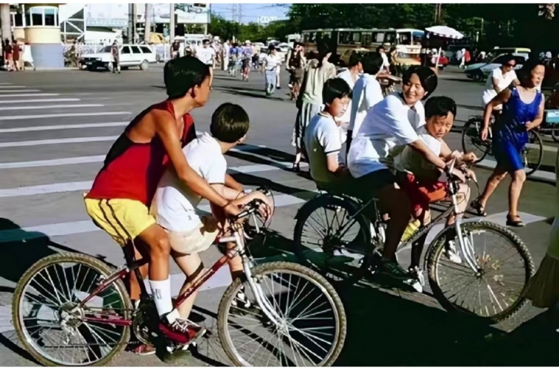 北京的老照片里,一个温暖而朴实的画面呈现在眼前:一对父母骑着自行车