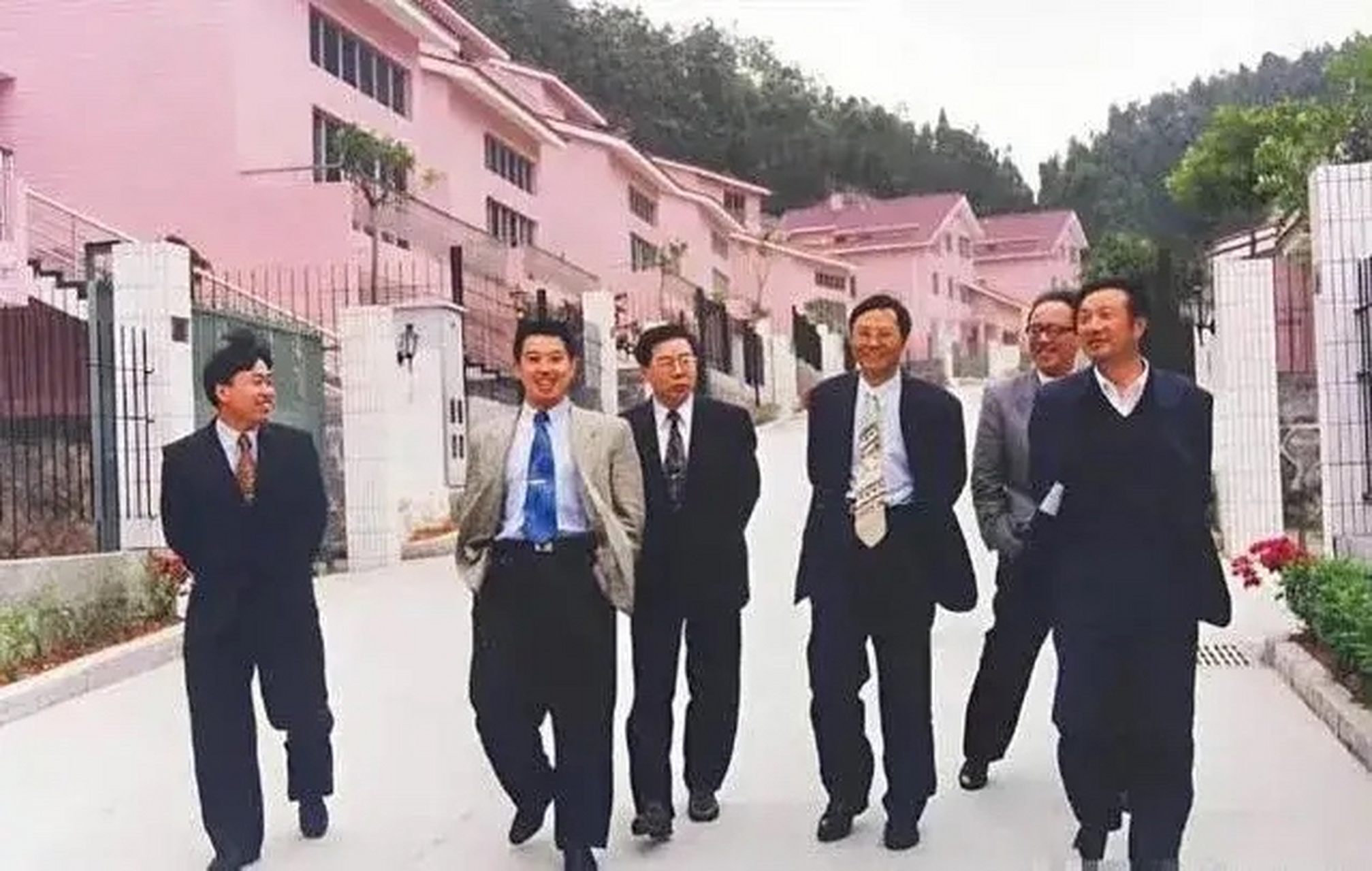 这是1987年任正非与他创业团队的一张合影,照片中后面是一排别墅,他们