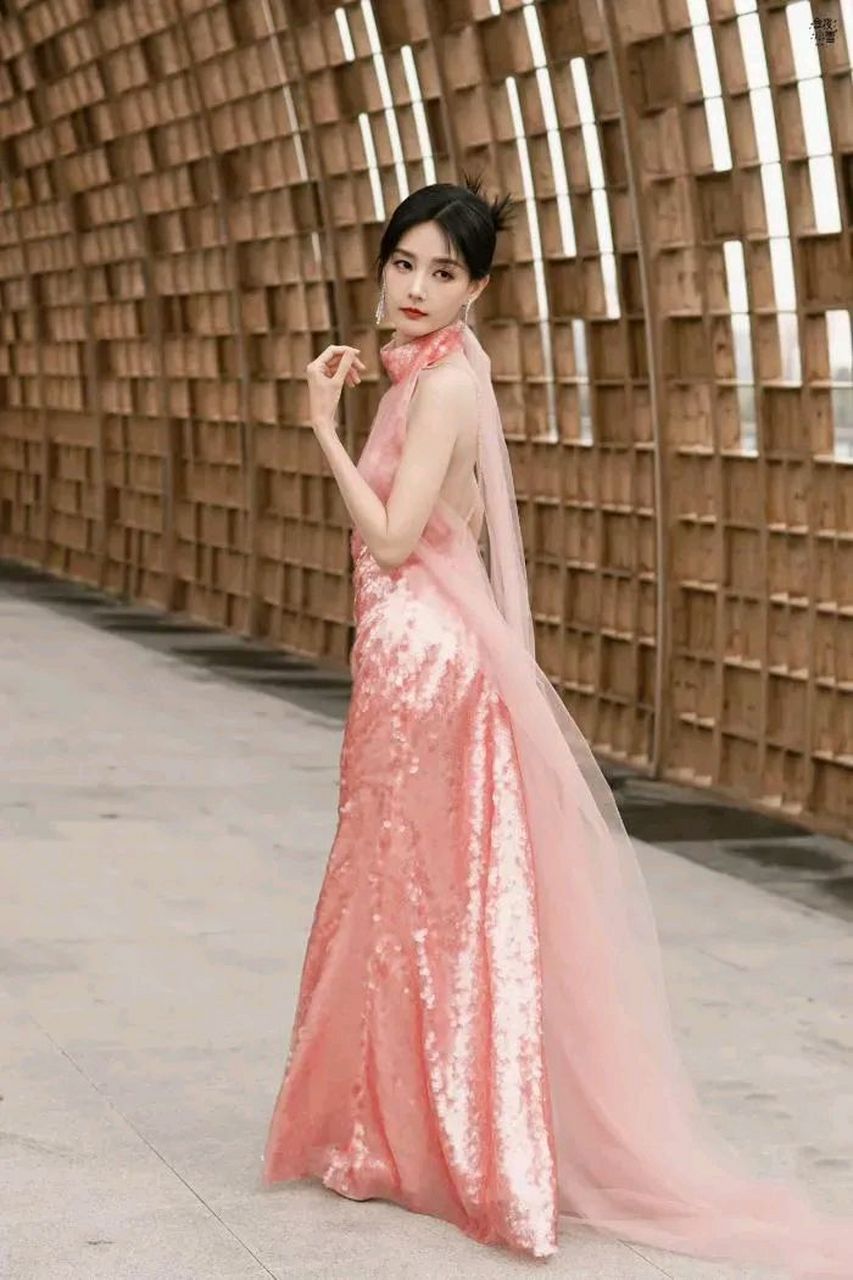 李一桐身穿粉色连衣裙,展现青春活力  李一桐近期在金色的堆叠背景下