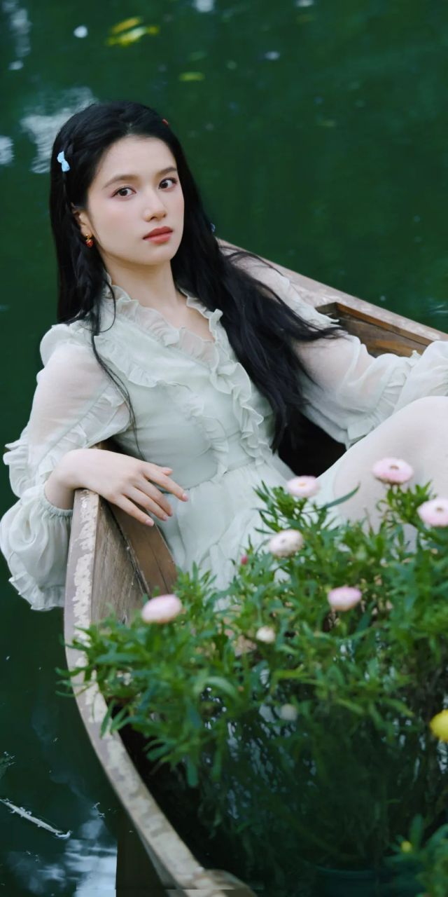 张婧仪生日写真. 她身着绿色纱裙,在草坪上嬉戏.