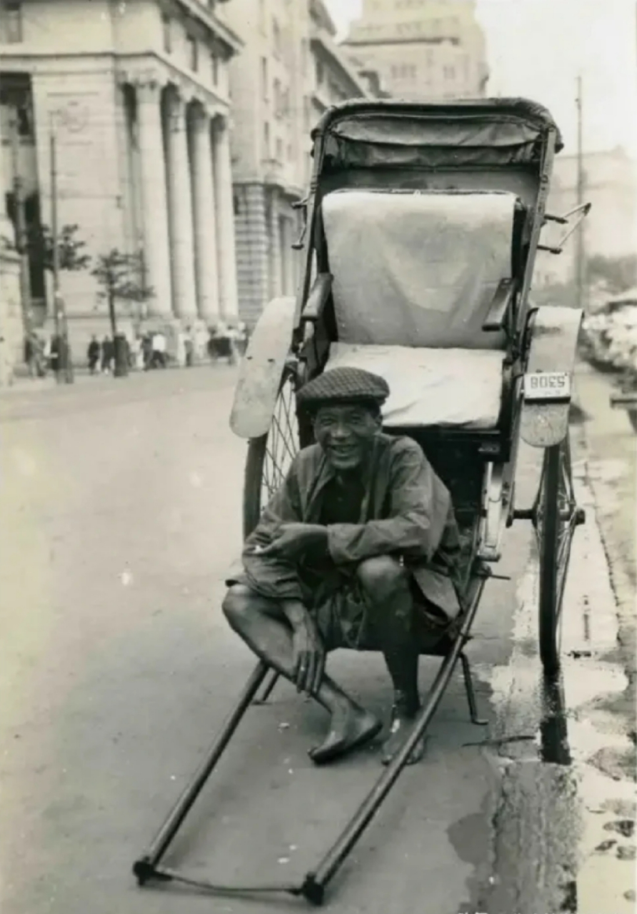 民国时期,蹲坐在黄包车上的车夫,面对镜头,他露出纯朴而善良的微笑!
