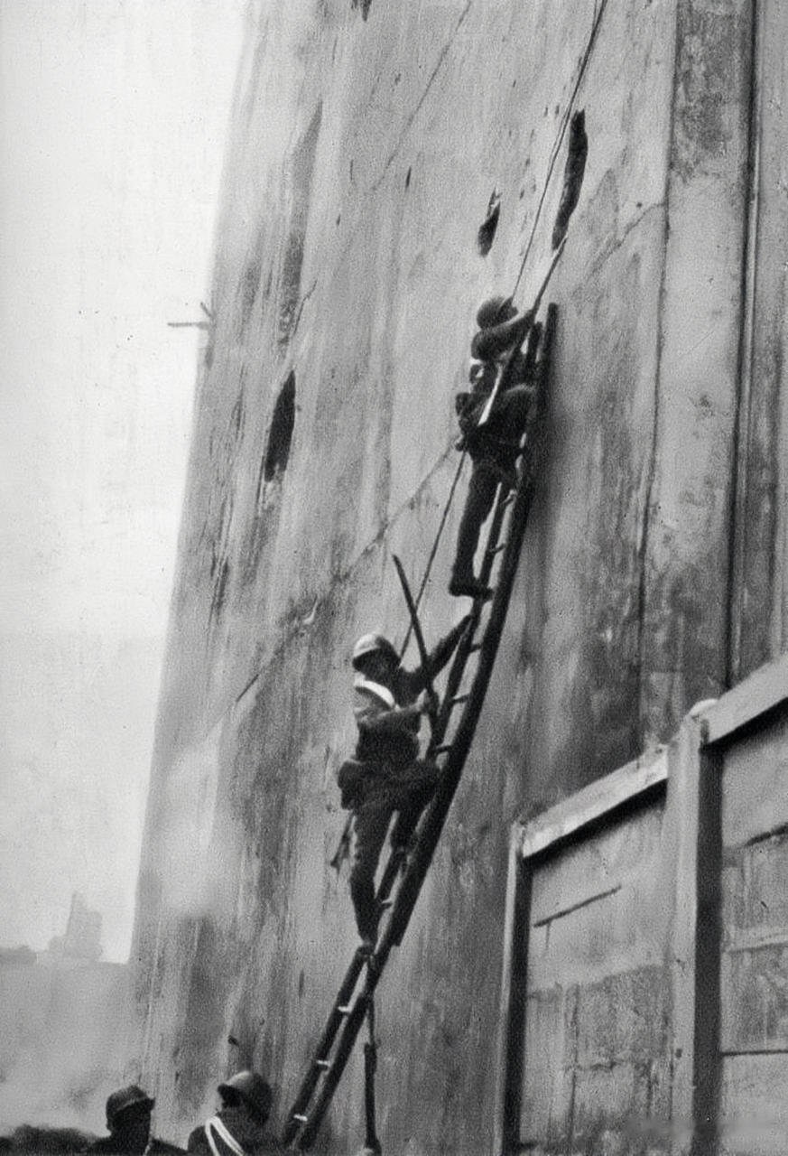 上海四行仓库保卫战,日军试图用楼梯进入仓库内,仓库外围满是弹孔;这