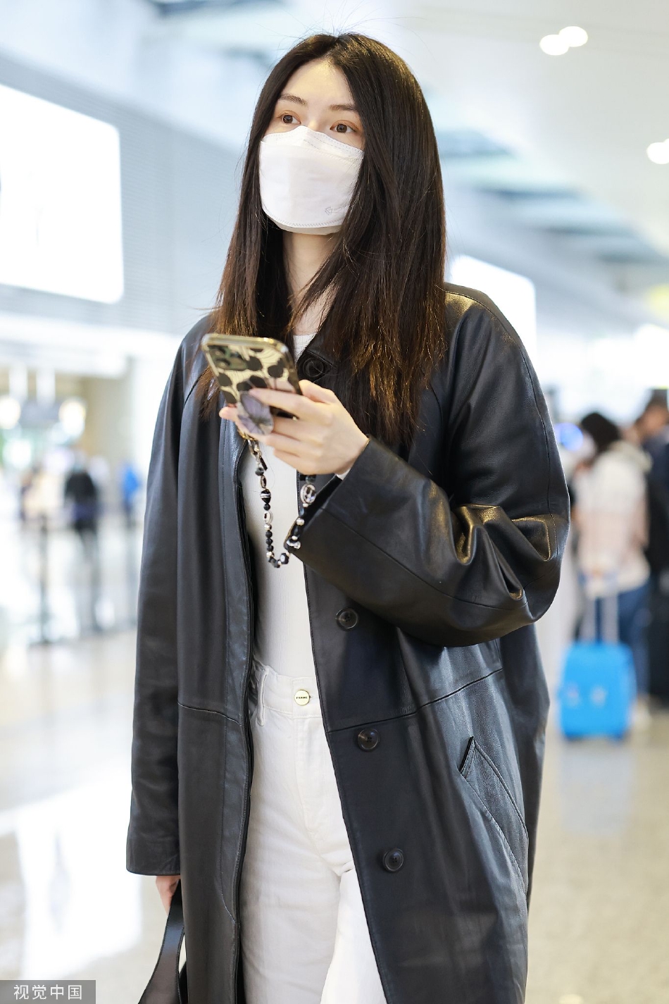 组图:何穗穿黑色皮大衣现身机场 长发披肩清冷感十足