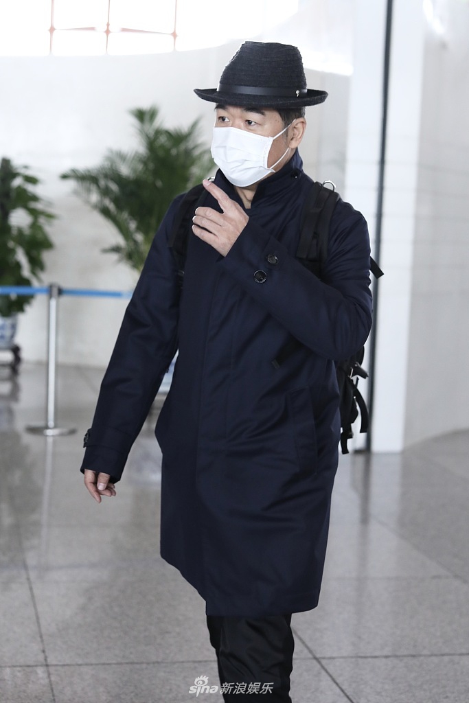 组图:张国立黑色look现身机场 背双肩包大步流星精气神足