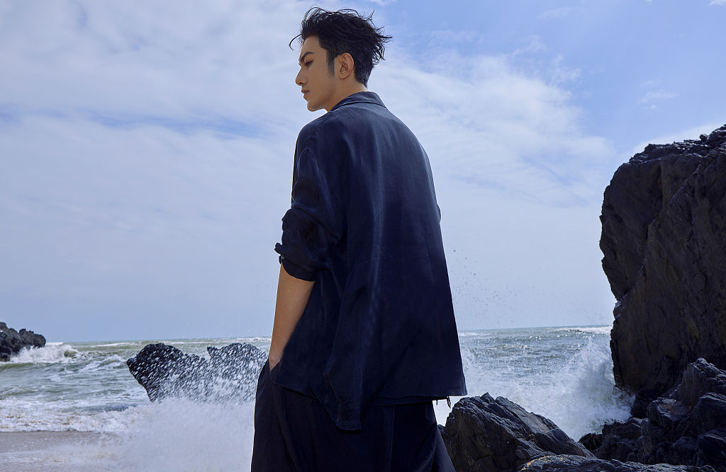 肖顺尧晒海边库存写真 蓝色衬衫内搭低领背心型男范