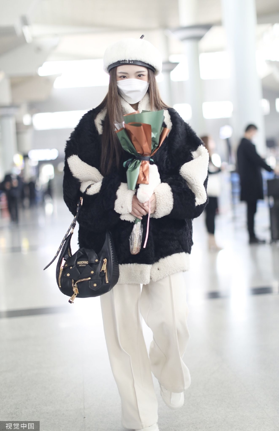 组图:郑乃馨戴白色贝雷帽现身机场 手捧粉丝赠送花束笑眼弯弯