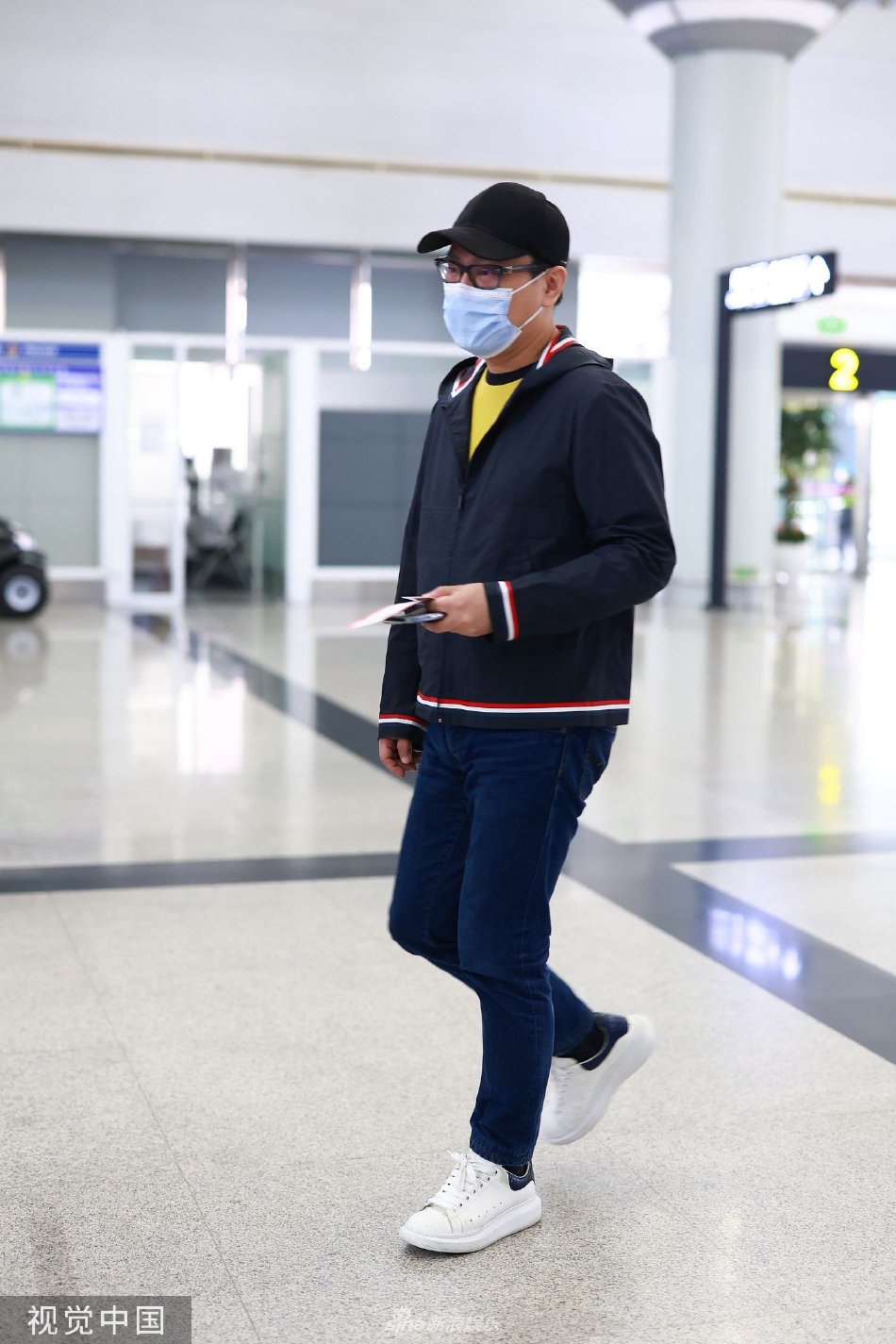 组图:张信哲戴棒球帽现身长沙机场 手拿机票身旁不见工作人员