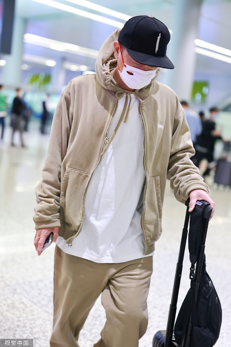组图:陈小春穿休闲套装现身机场 戴鸭舌单手拉行李酷劲十足