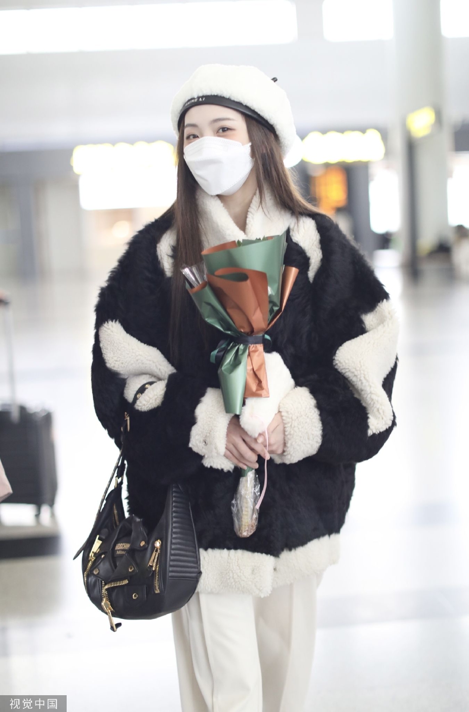 组图:郑乃馨戴白色贝雷帽现身机场 手捧粉丝赠送花束笑眼弯弯