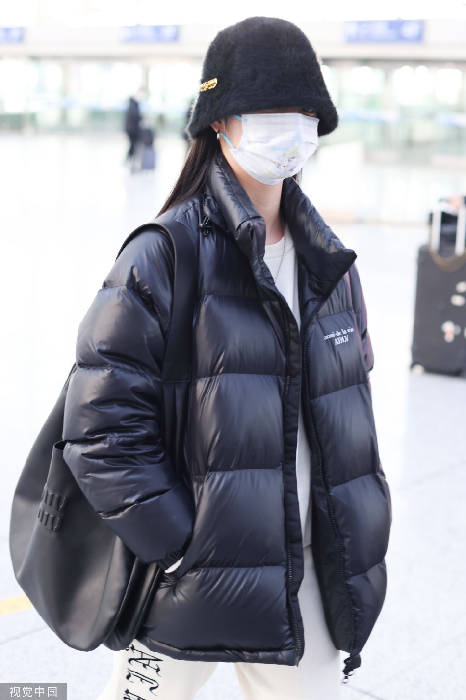 组图:周洁琼渔夫帽配黑色羽绒服现身机场 穿搭休闲舒适
