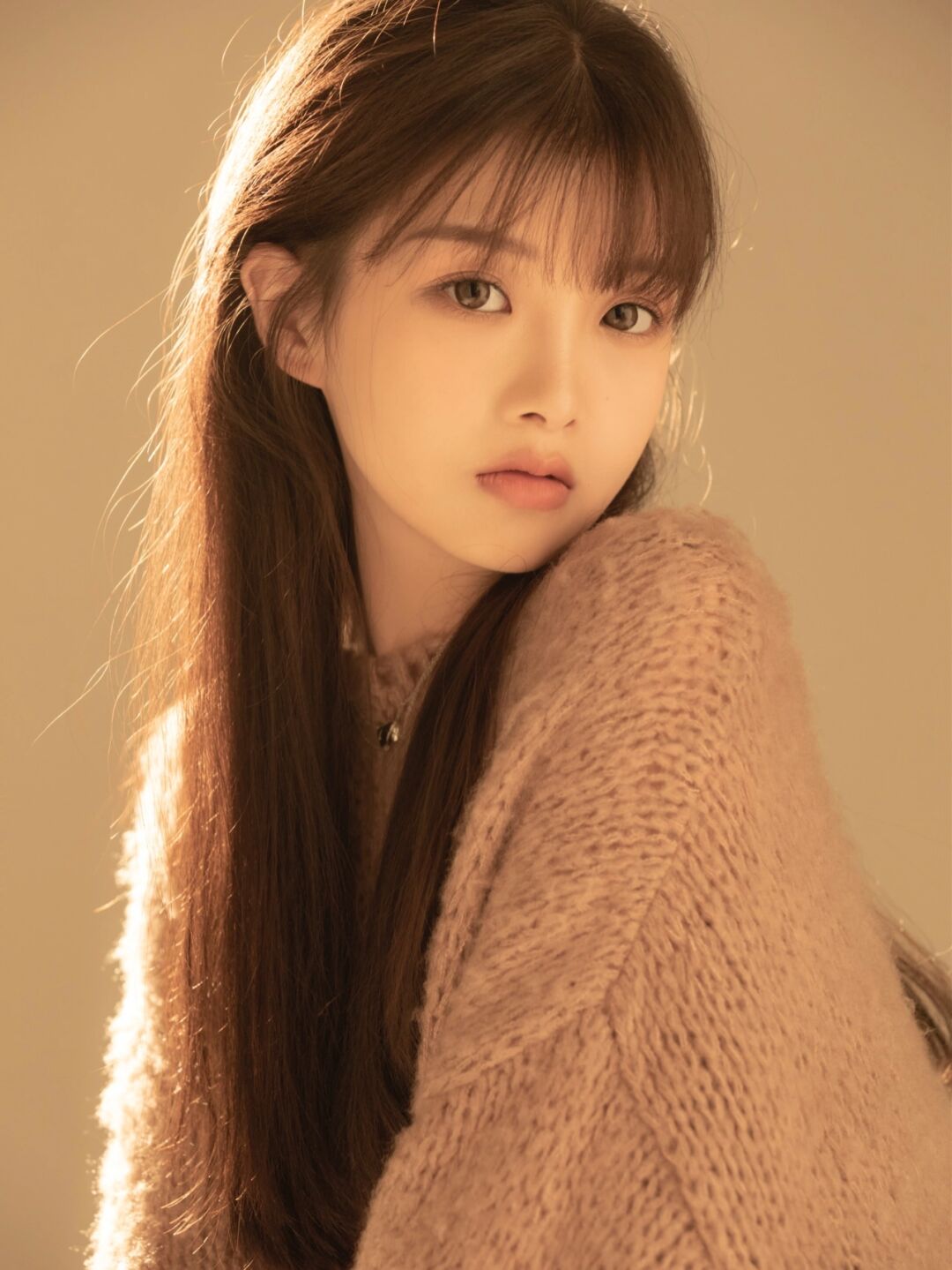 橘黄色灯光下的女人真美棕色毛衣很得体长相很大气的美女