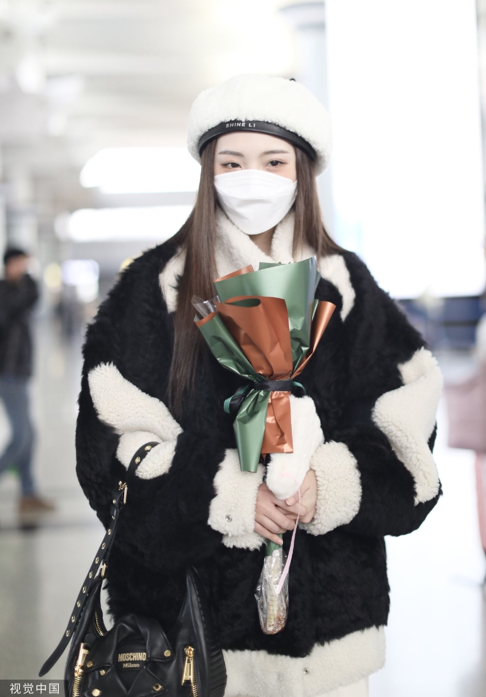 组图:郑乃馨戴白色贝雷帽现身机场 手捧粉丝赠送花束笑眼弯弯