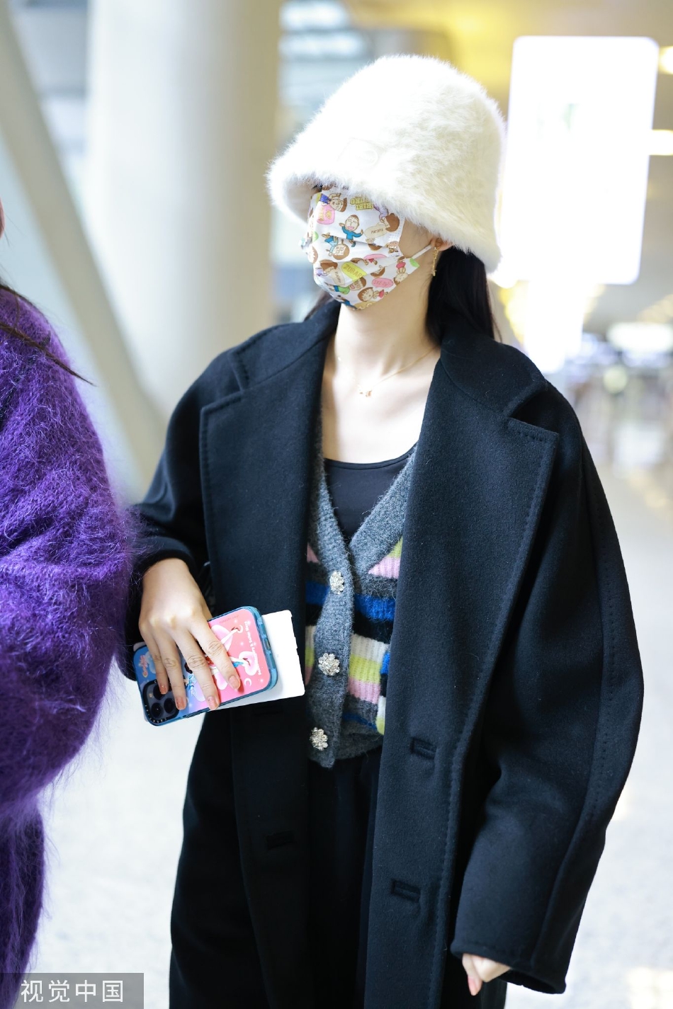 组图:周也黑色大衣现身机场 卡通口罩毛绒帽子少女心爆棚