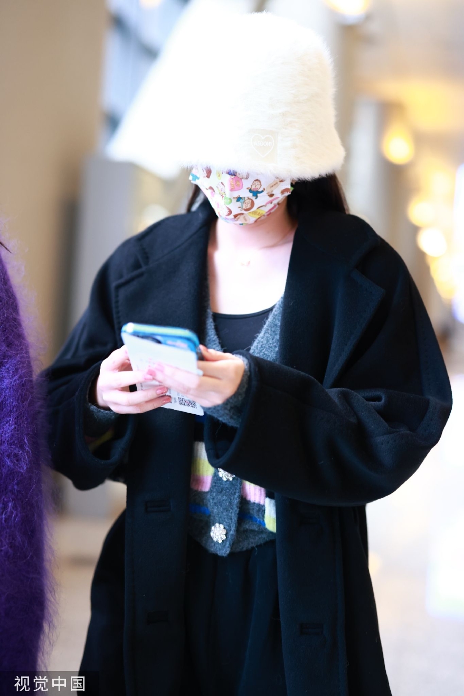 组图:周也黑色大衣现身机场 卡通口罩毛绒帽子少女心爆棚