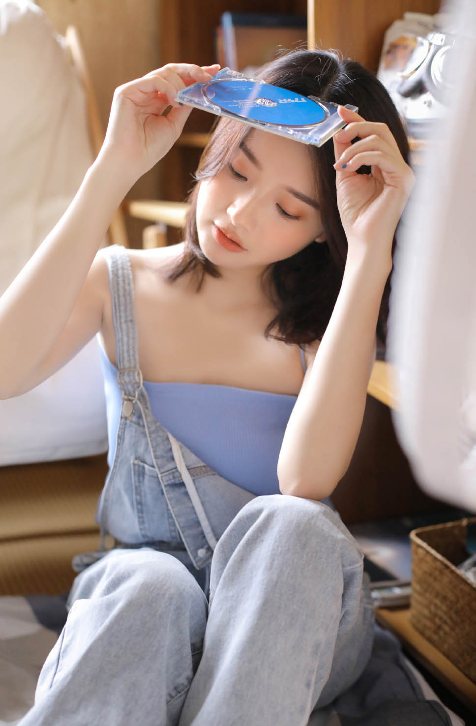 美女身穿蓝色吊带衫搭配牛仔背带裤时尚写真