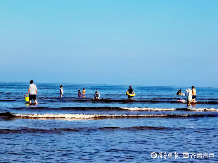 荣成海滩退潮以后,赶海和游玩的人们各有各的乐趣