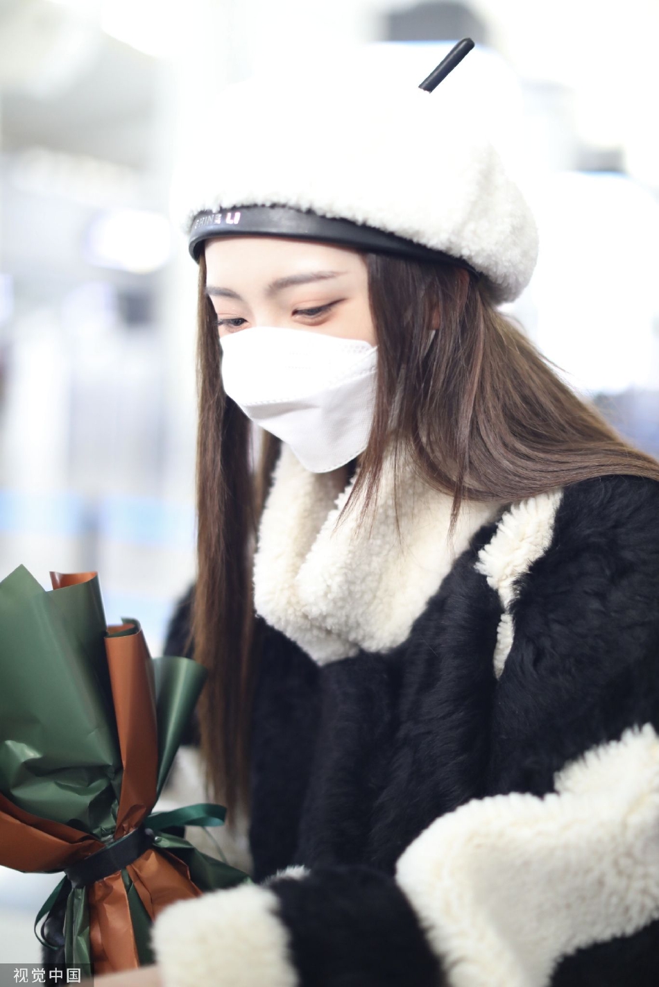 组图:郑乃馨戴白色贝雷帽现身机场 手捧粉丝赠送花束笑眼弯弯