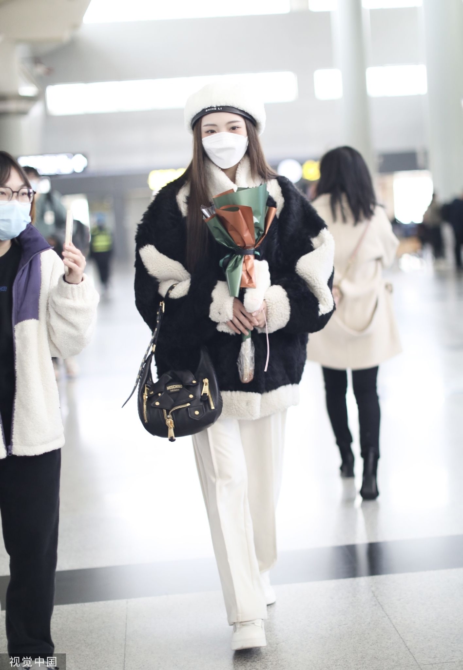 组图:郑乃馨戴白色贝雷帽现身机场 手捧粉丝赠送花束笑眼弯弯