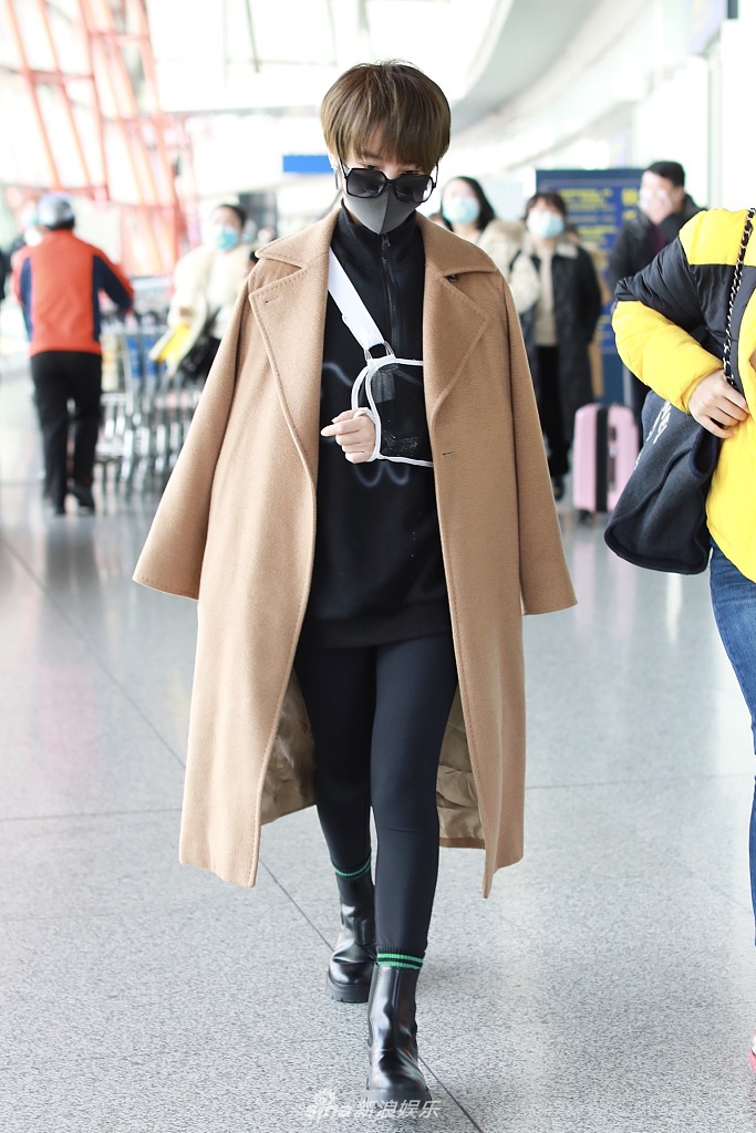 组图:谢楠左手骨折后戴护具亮相机场 披大衣走路带风状态好
