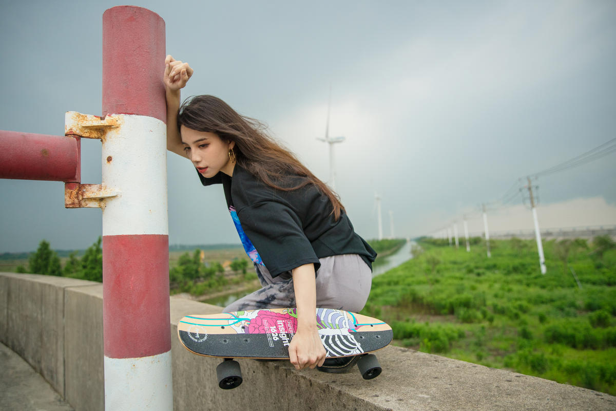 海边玩滑板的少女