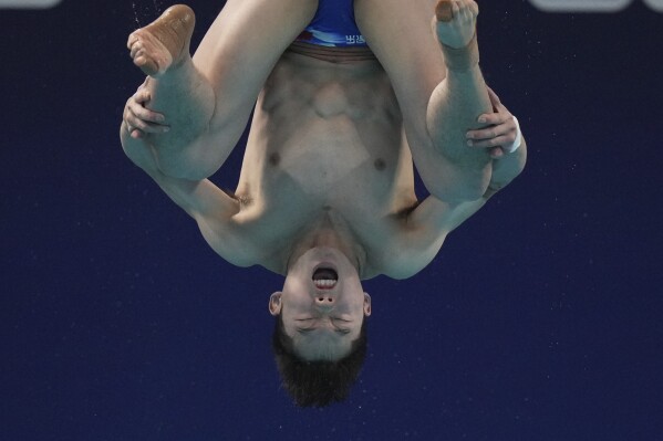 美联社照片:跳水板与水面之间瞬间中跳水者的表情