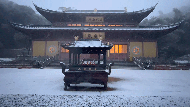 良渚东明寺的地面,屋檐,都铺上了一层浅浅的雪花,雪伴着风从天而降